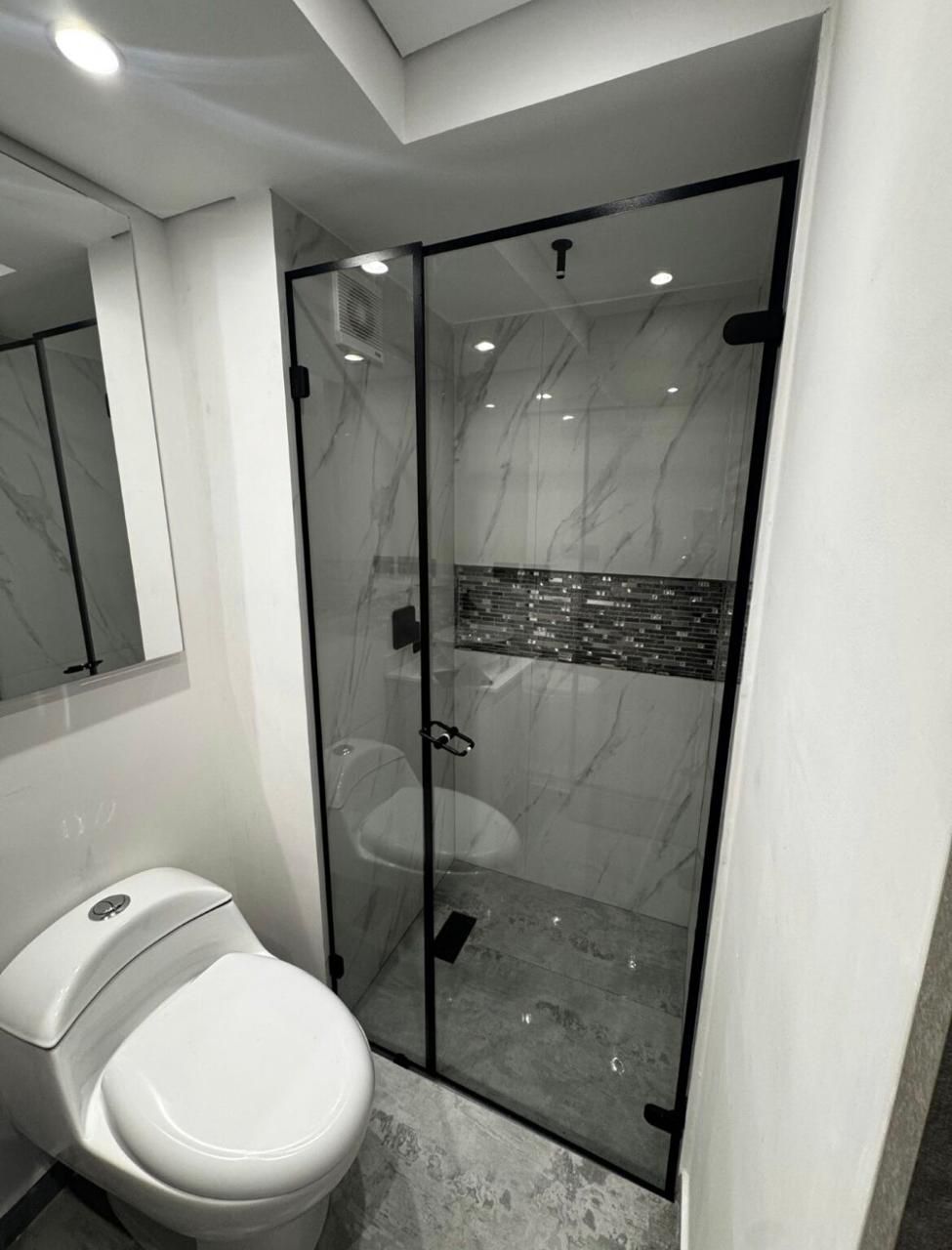 Baño moderno con división en vidrio templado