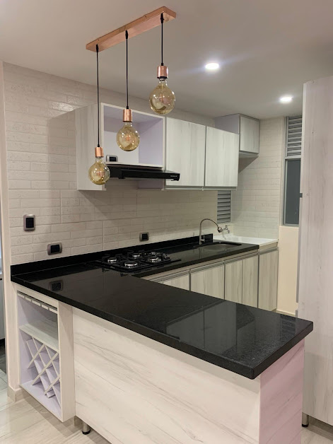 Cocina con barra en granito negro y lámparas colgantes