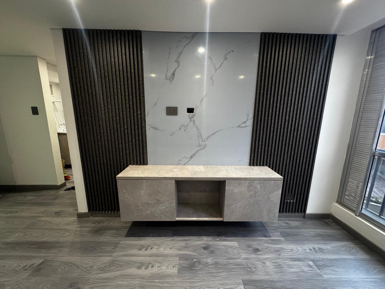 Mueble TV con panel en mármol y listones negros